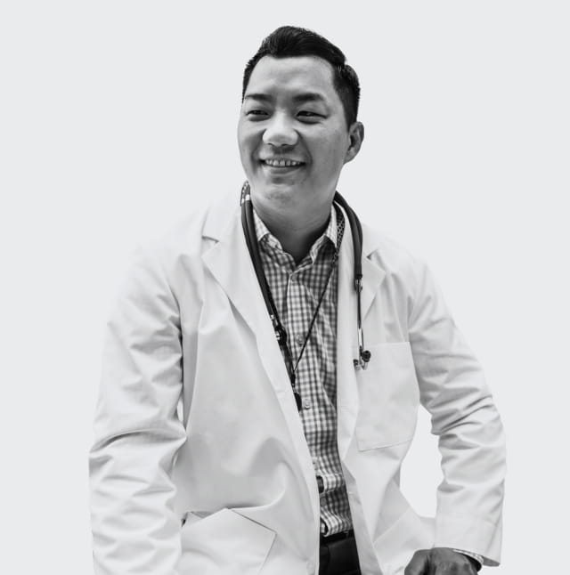 A doctor smiling and posing for a picture.
